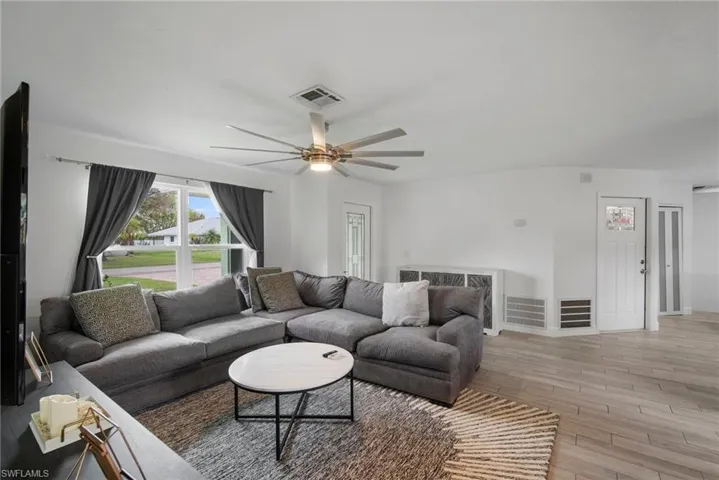 Living room featuring ceiling fan and light hardwood / wood-style flooring