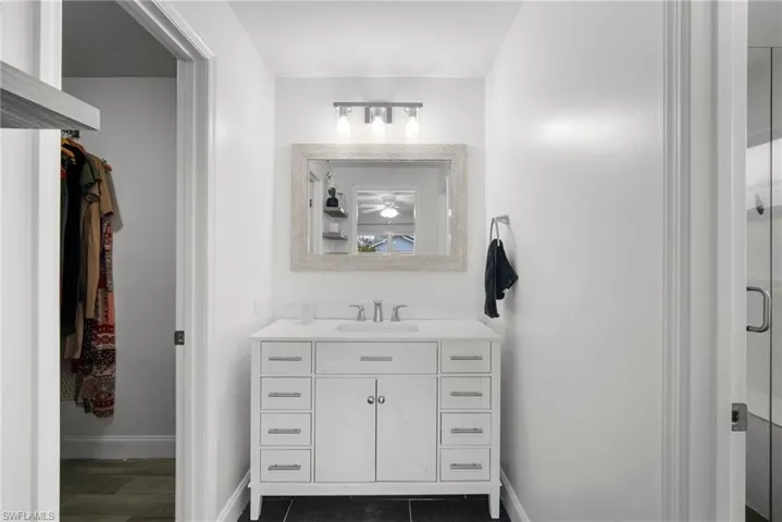 Bathroom with hardwood / wood-style flooring, vanity, and walk in shower