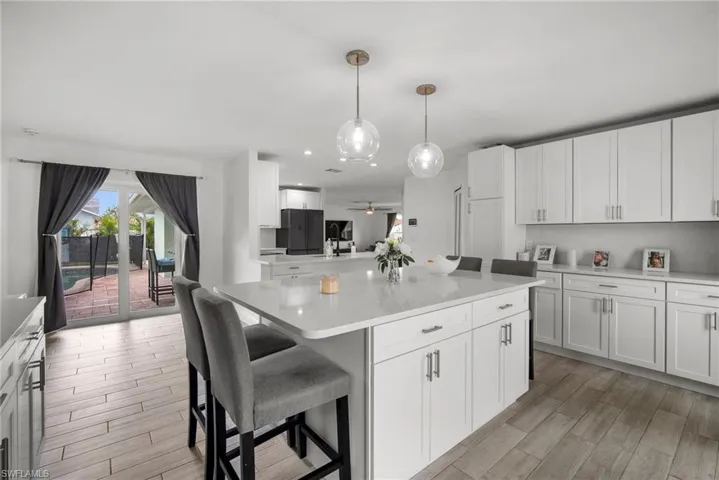 Kitchen featuring ceiling fan, white cabinetry, and light wood-type flooring