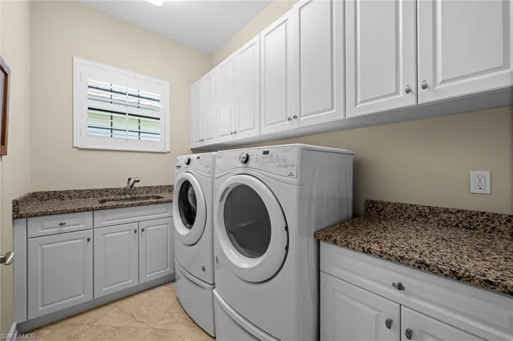 A spacious laundry room with abundant cabinetry and plenty of workspace.