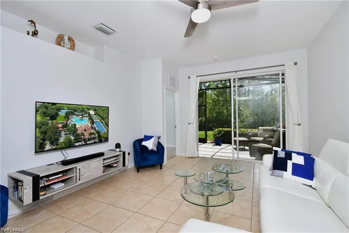 Living room featuring light tile patterned floors and ceiling fan
