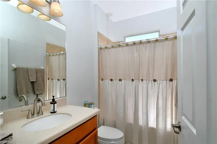 Bathroom featuring vanity, toilet, and a shower with curtain