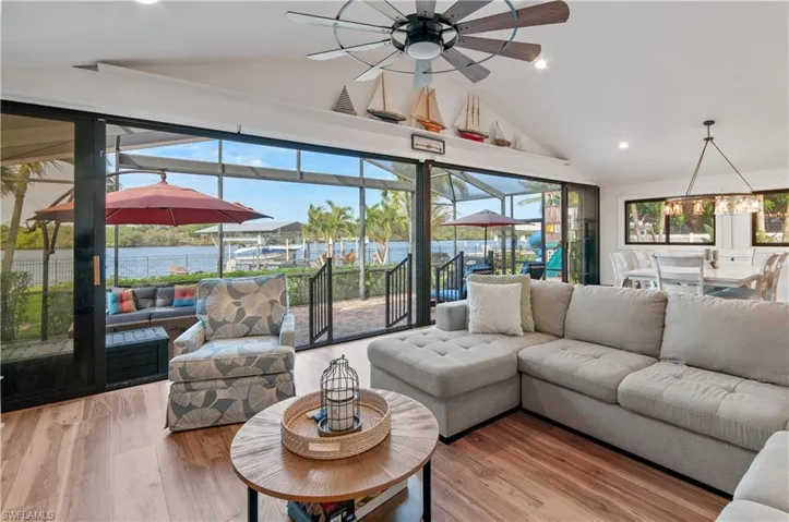 Living room with a sunroom, wood finished floors, vaulted ceiling, recessed lighting, and ceiling fan
