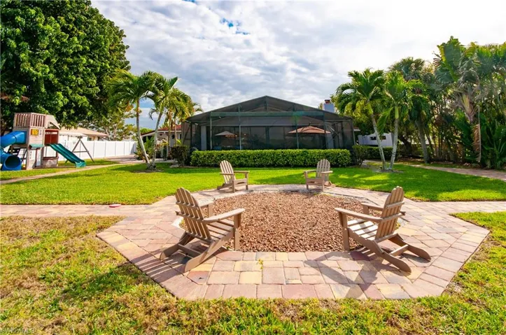 View of yard featuring a playground, glass enclosure, a patio, and a sunroom