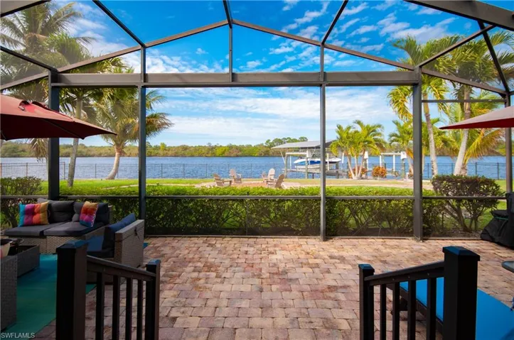 View of patio / terrace featuring glass enclosure, a sunroom, a water view, an outdoor hangout area, and a dock