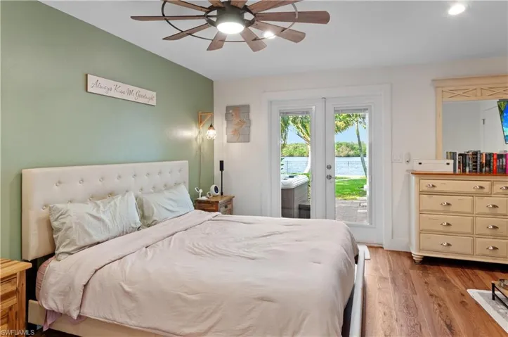 Bedroom featuring access to outside, light wood-style floors, a ceiling fan, and french doors