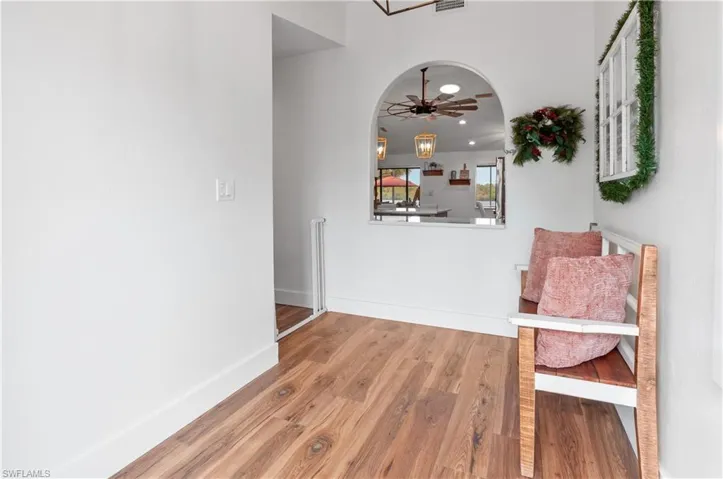 Hall with wood finished floors and arched walkways