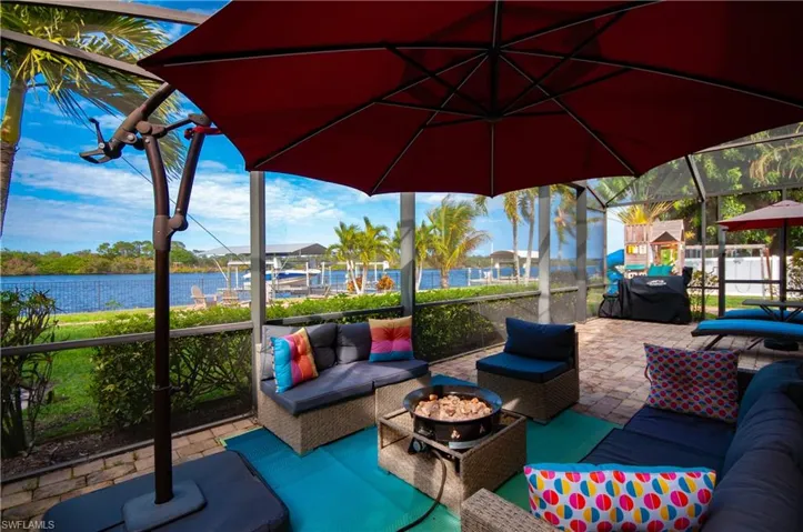 View of patio / terrace featuring an outdoor living space with a fire pit, a sunroom, a water view, and area for grilling