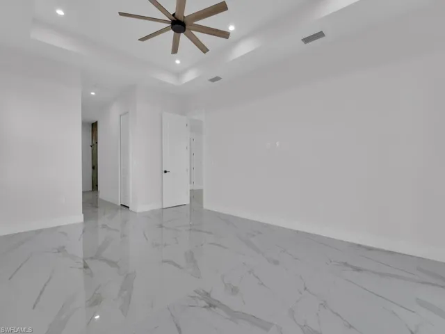 Primary  bedroom featuring a tray ceiling and closet.