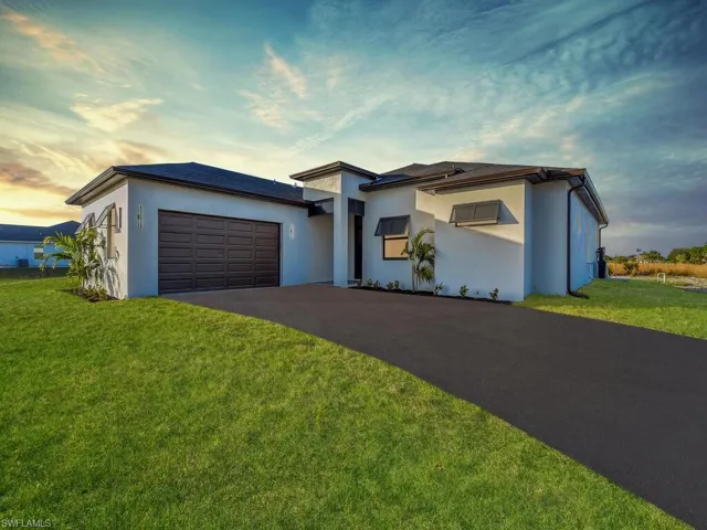 View of front of property with a lawn and a garage