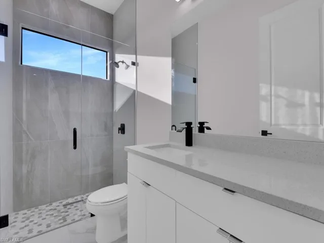 Bathroom with toilet, vanity, and walk in shower
