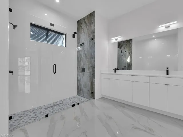 Primary Bathroom featuring vanity and walk in shower, 2 shower head, and double sink.