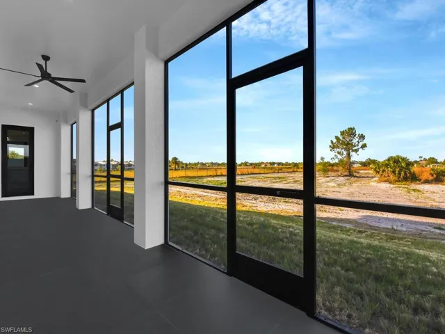 Unfurnished screened lanai featuring ceiling fan and a rural view