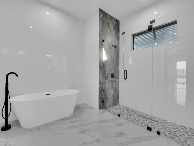 primary Bathroom featuring shower with separate bathtub.