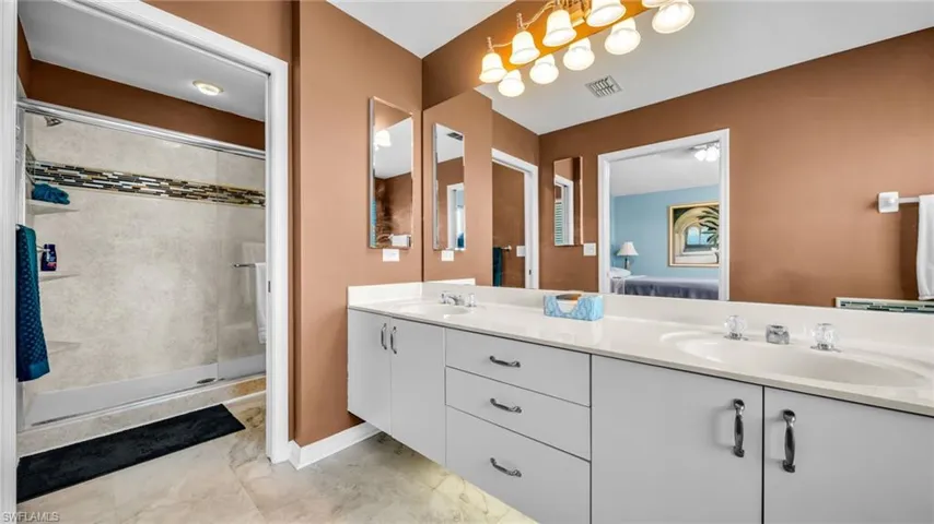 Full bath with double vanity, ensuite bathroom, tile shower with soaker tub
