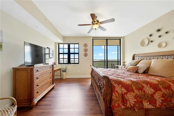 Bedroom featuring access to outside, wood finished floors, and a ceiling fan