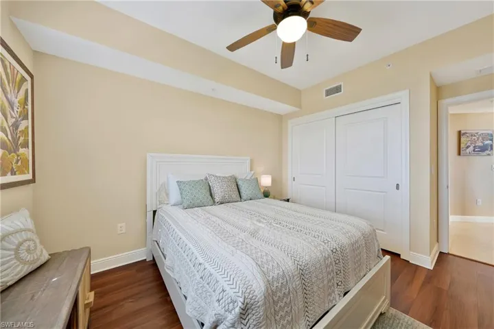 Bedroom with dark wood-type flooring, a ceiling fan, and a closet