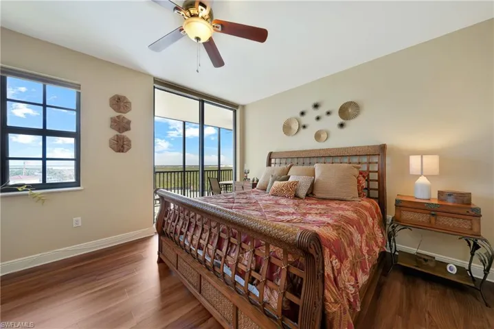 Bedroom with wood finished floors, access to exterior, and a ceiling fan