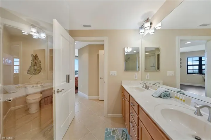 Bathroom featuring double vanity and light tile patterned floors