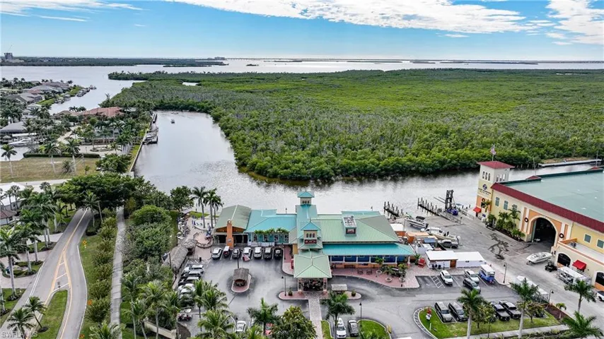 Drone / aerial view of a nearby body of water and a heavily wooded area