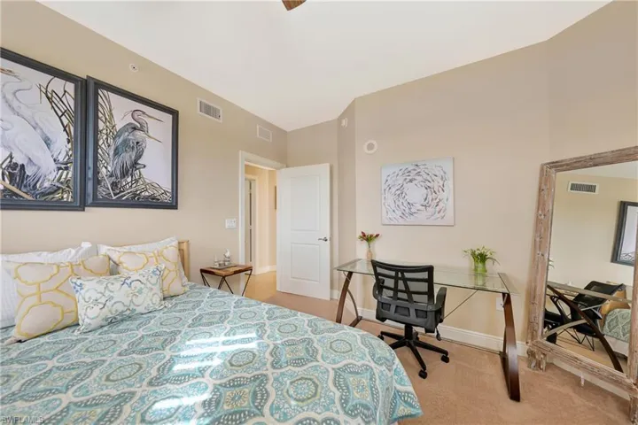 Bedroom featuring light colored carpet and an office area