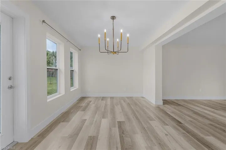 Unfurnished dining area featuring an inviting chandelier and light hardwood / wood-style floors