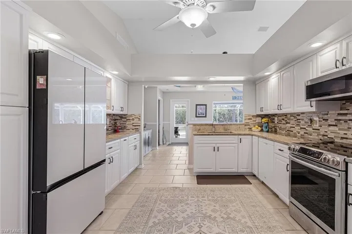 Kitchen with tile floors, lots of cabinets, and granite countertops.