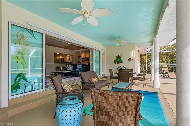 Covered sitting area by the pool with sliding glass doors that go in to the living area