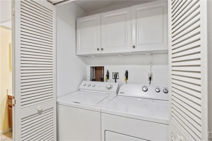 Washroom with cabinets and washer and dryer
