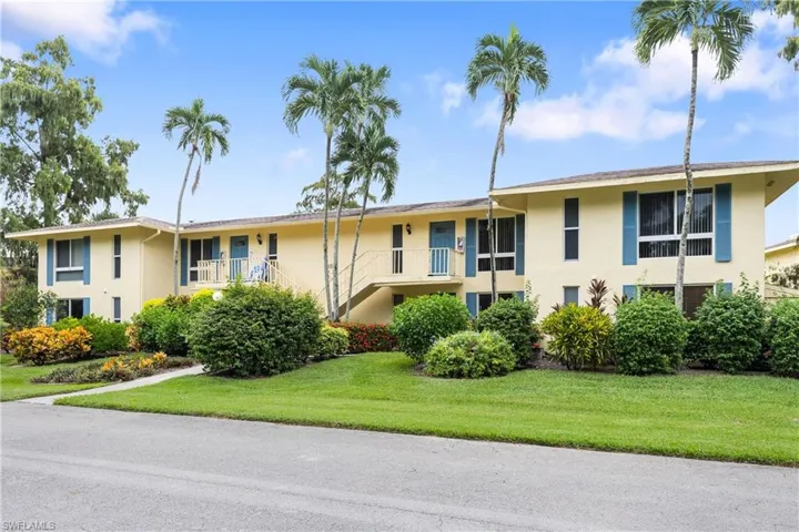 View of front of home featuring a balcony and a front lawn