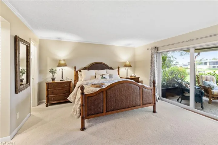 Carpeted bedroom with ornamental molding and access to outside