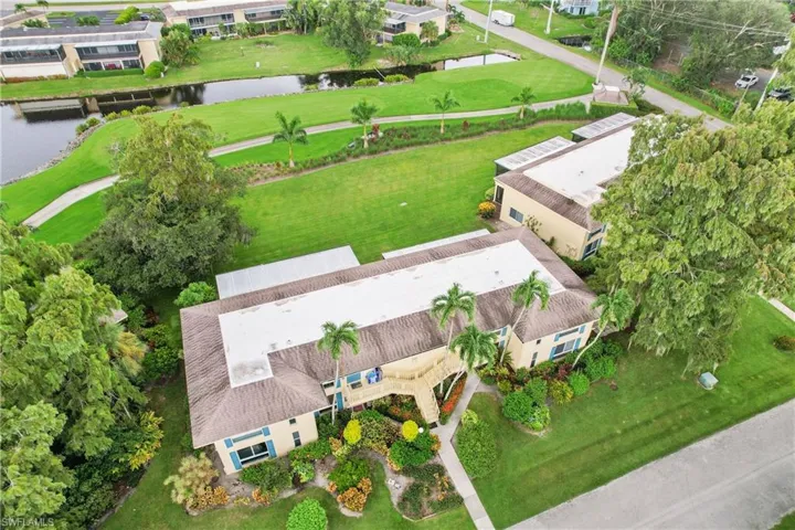 Birds eye view of property featuring a water view, swimming pool and golf course