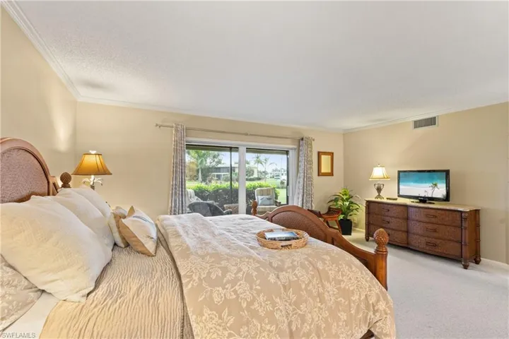 Carpeted bedroom with access to outside, a textured ceiling, and crown molding