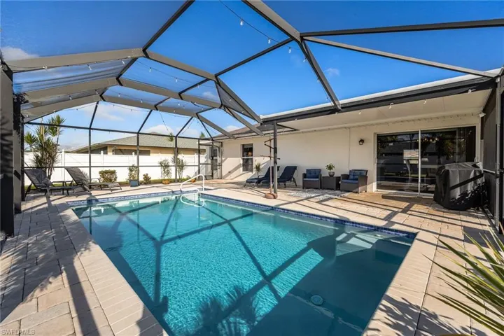 View of pool featuring a patio, glass enclosure, and a sunroom