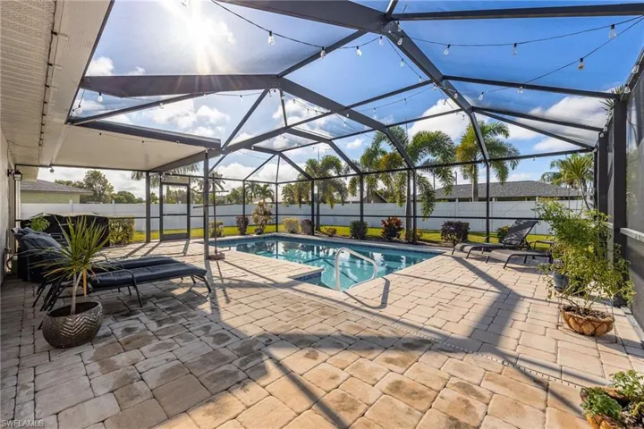 View of swimming pool with a lanai, a patio area, a fenced backyard, and a sunroom
