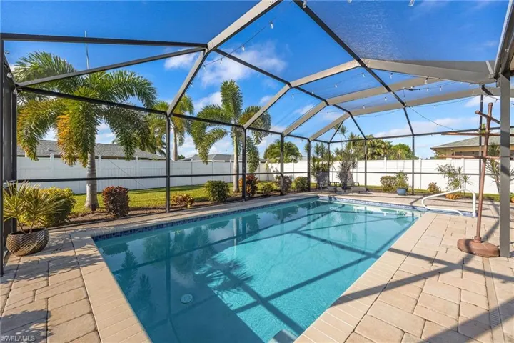 View of swimming pool featuring glass enclosure, a sunroom, a fenced backyard, and a patio