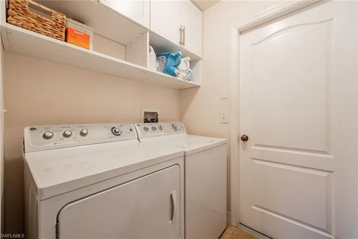 Washroom with washer and clothes dryer and cabinet space