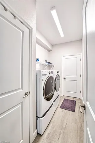 Laundry room featuring light hardwood / wood-style flooring and separate washer and dryer