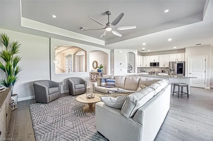 Kitchen with a kitchen island with sink, appliances with stainless steel finishes, sink, and white cabinets
