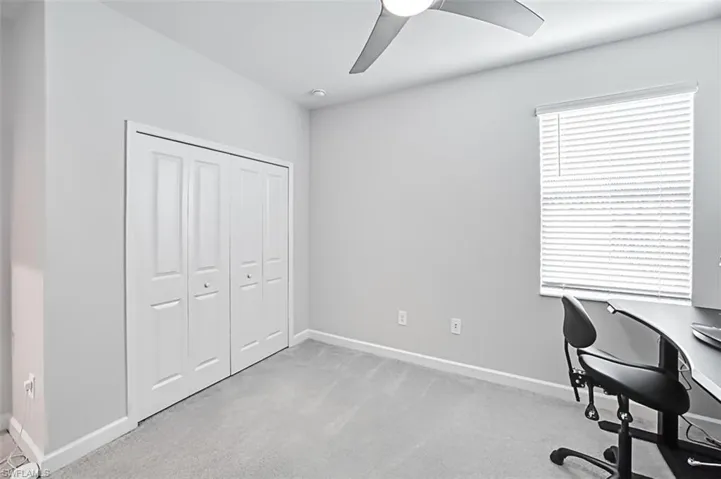 Carpeted home office with ceiling fan