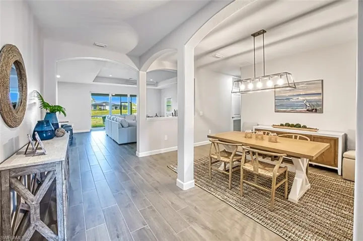 Dining area with hardwood / wood-style floors and a tray ceiling