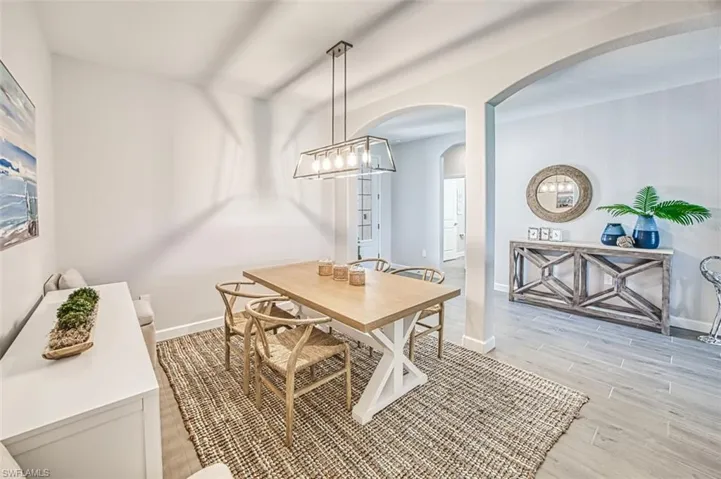 Dining room with light hardwood / wood-style flooring and a notable chandelier