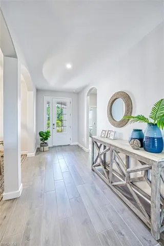 Living room featuring ceiling fan, a raised ceiling, and light hardwood / wood-style flooring
