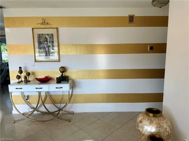 Entry featuring gold-stripe accent wall