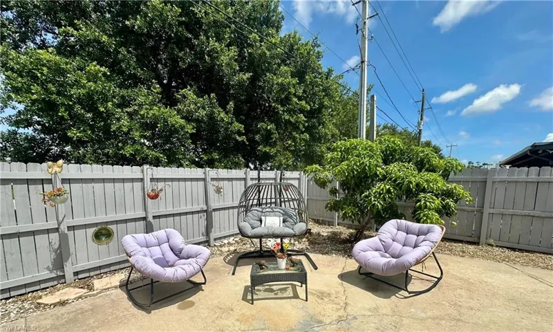Paved patio area with a wooden privacy fence