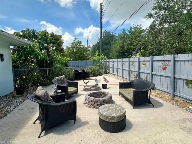 Paved backyard patio with a privacy fence and mature perimeter trees