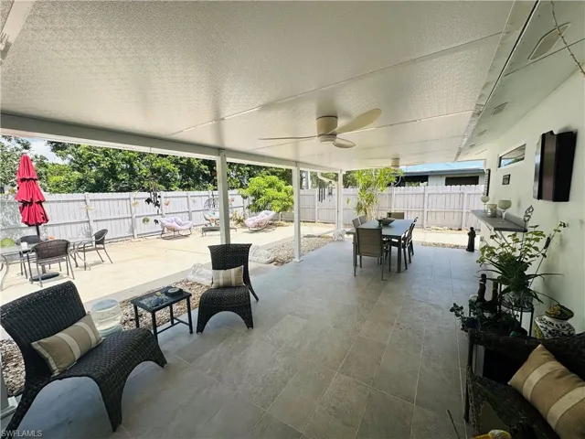 Expansive covered patio featuring a full ceiling, dual ceiling fans, and tiled flooring