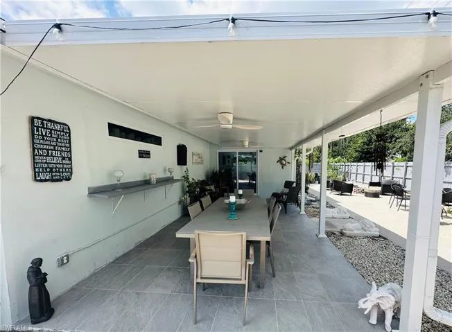 Expansive covered patio featuring a full ceiling, dual ceiling fans, and tiled flooring
