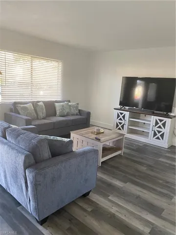 Living area with dark wood-type flooring