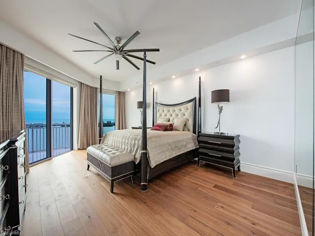 Bedroom featuring a water view, access to outside, hardwood / wood-style floors, recessed lighting, and ceiling fan